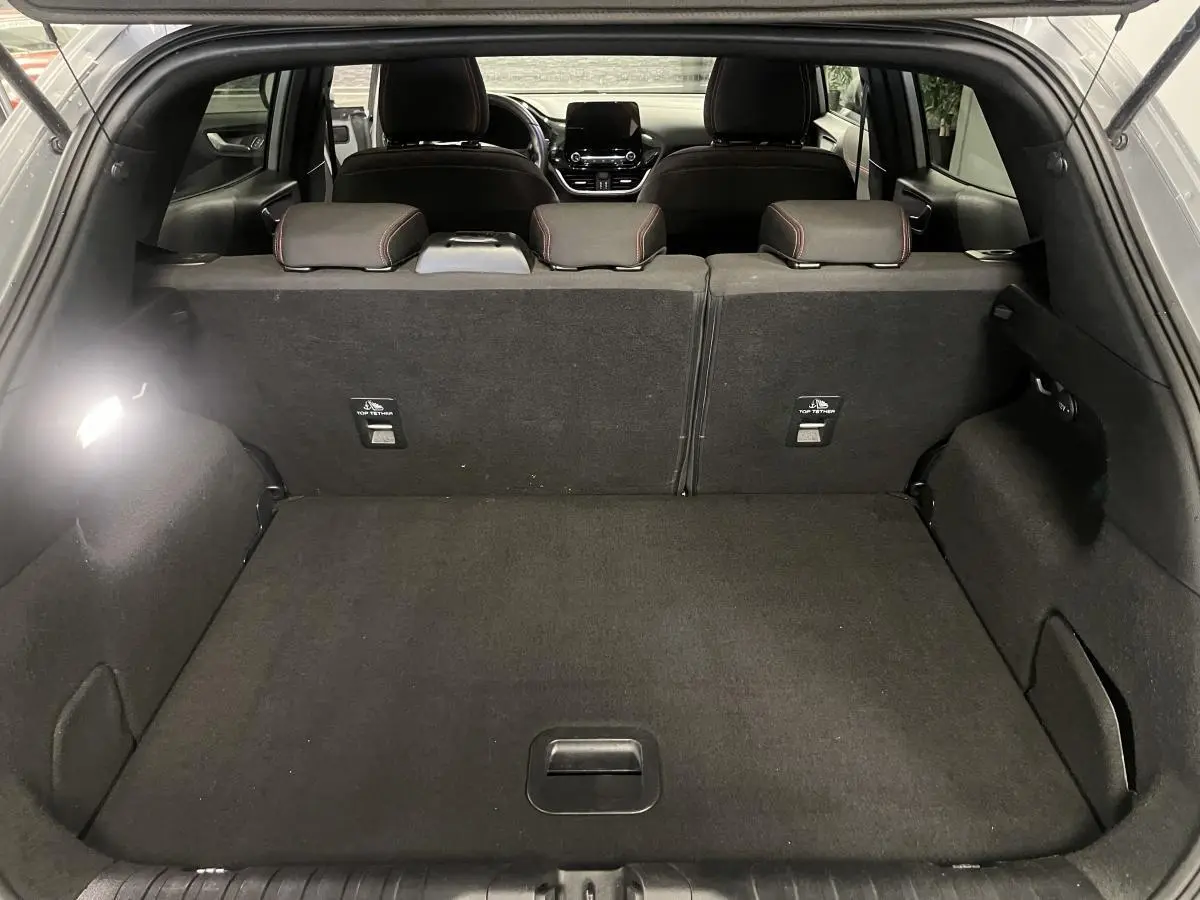 Coffre spacieux vu de l'arrière ouvert d'un Ford Puma gris avec banquette arrière noire et appuie-têtes visibles.