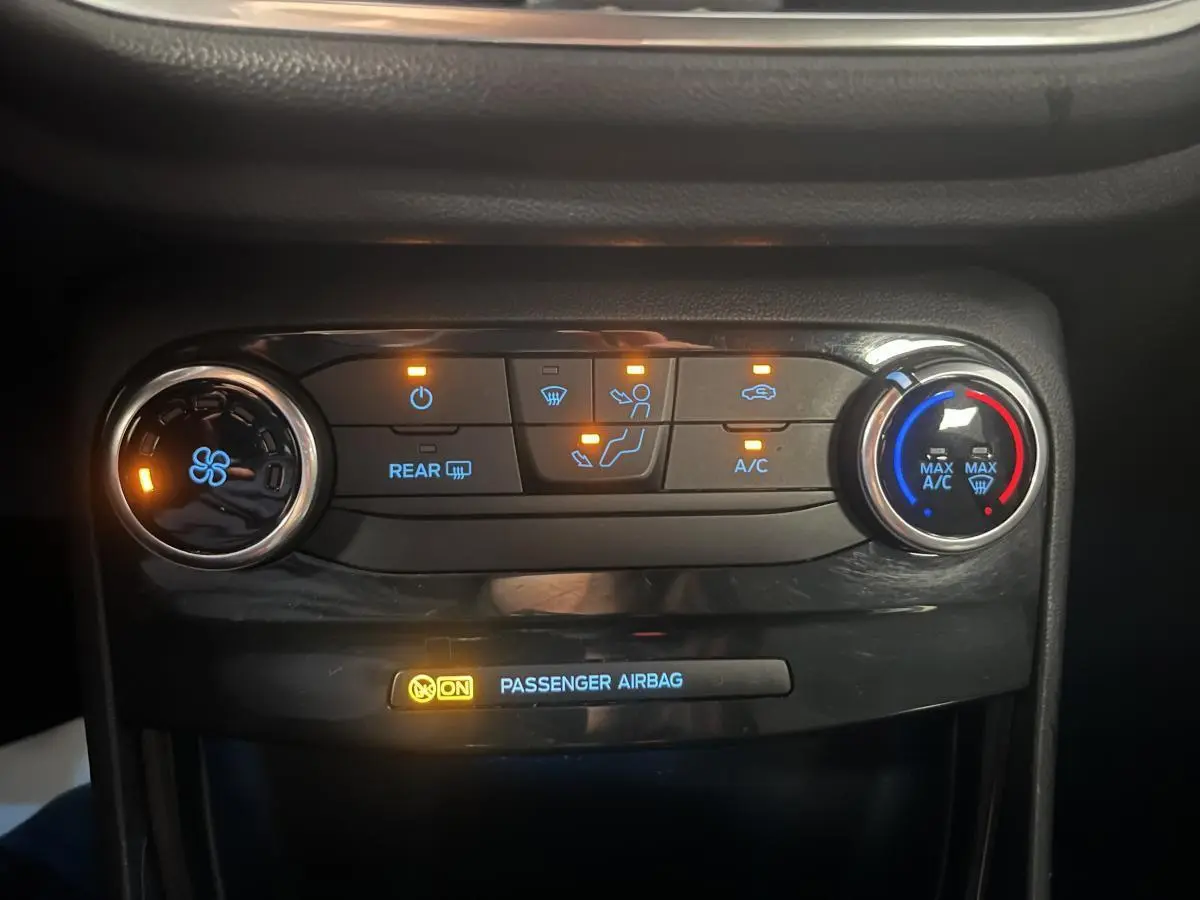 Panneau de commande de climatisation avec voyants allumés dans l'habitacle d'une Ford Puma gris 2021.