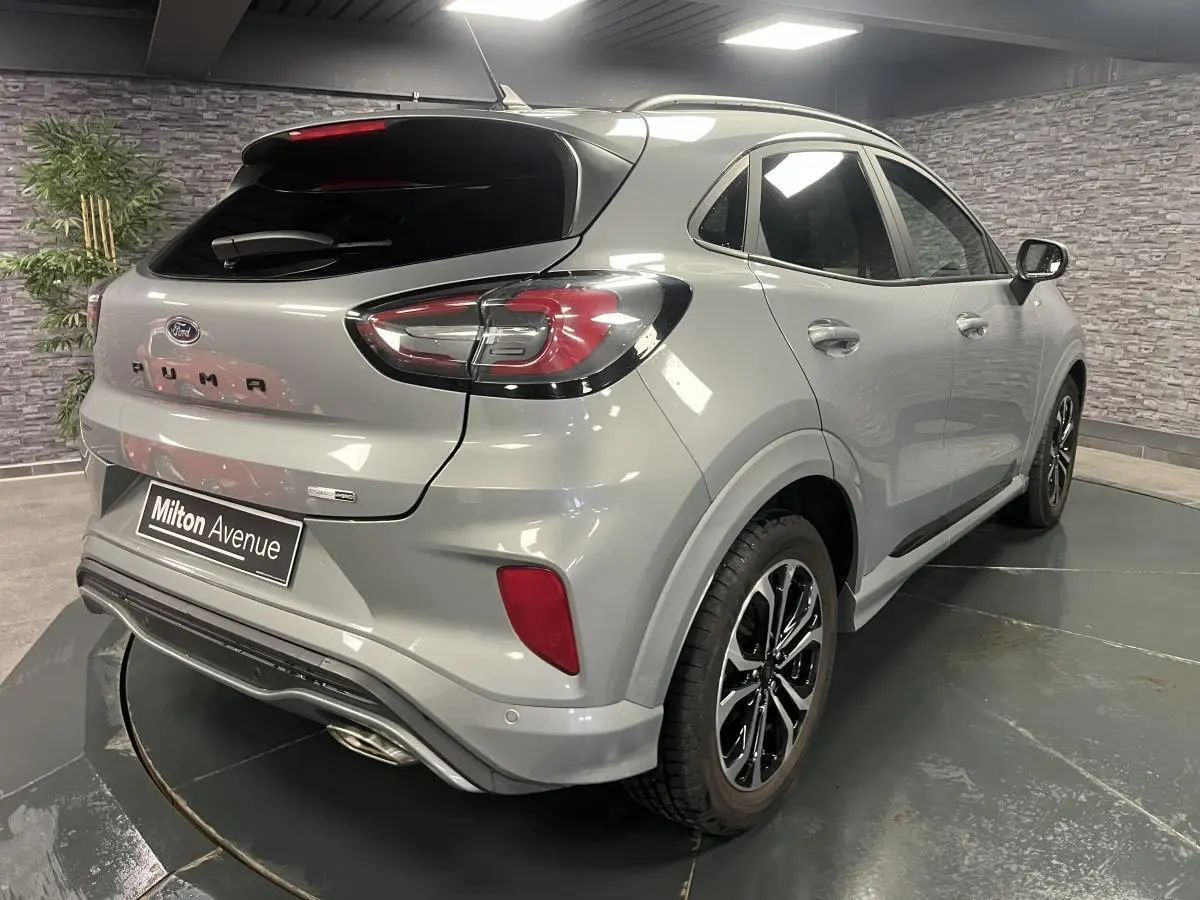 Vue 3/4 arrière droite du Ford Puma gris métallisé avec barres de toit noires et jantes alliage 17 pouces.