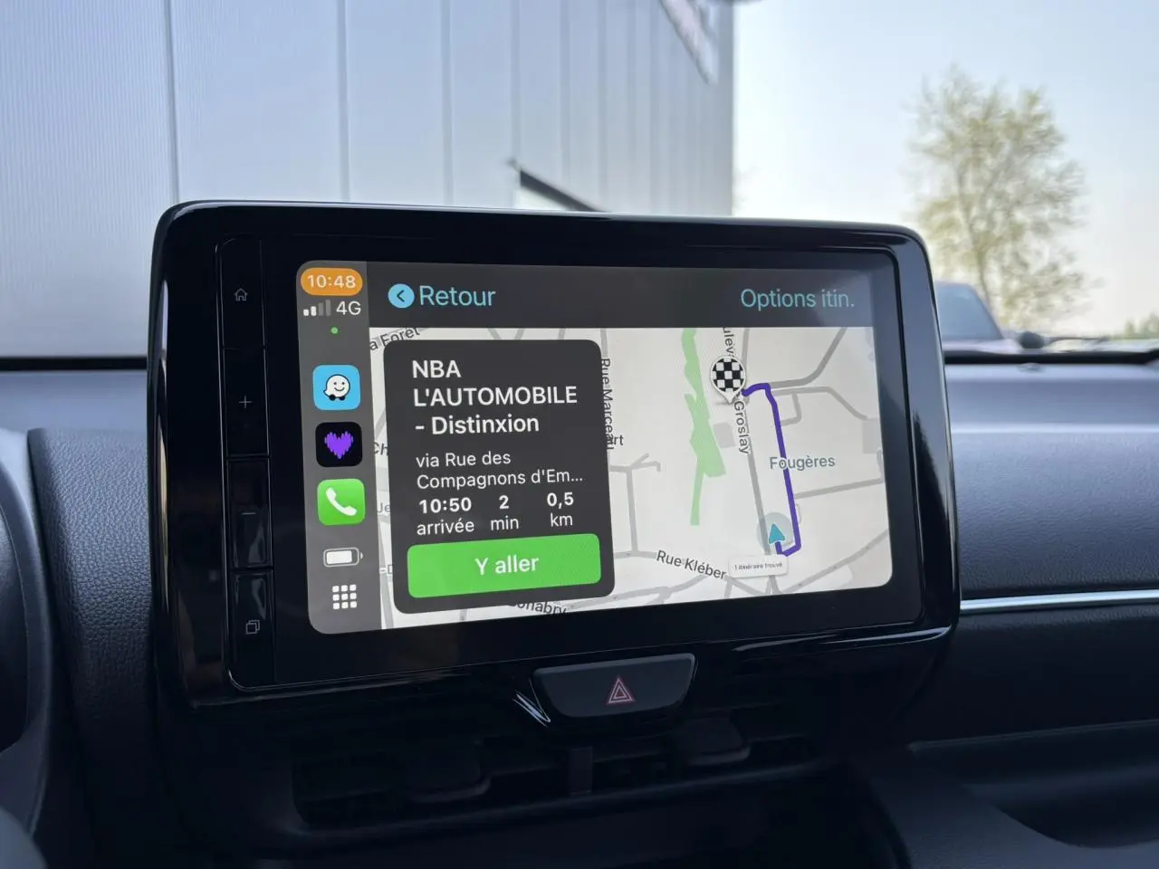 Écran tactile central de la Toyota Yaris hybride 2025 affichant un itinéraire de navigation en intérieur noir.