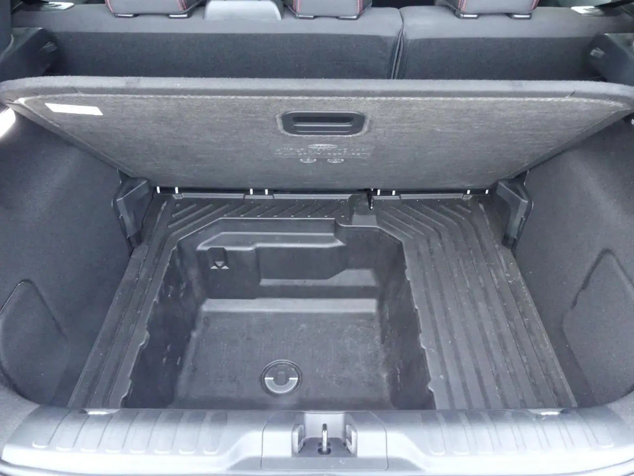 Coffre ouvert vu de dessus du Ford Puma blanc 2020, montrant le compartiment de rangement sous plancher.