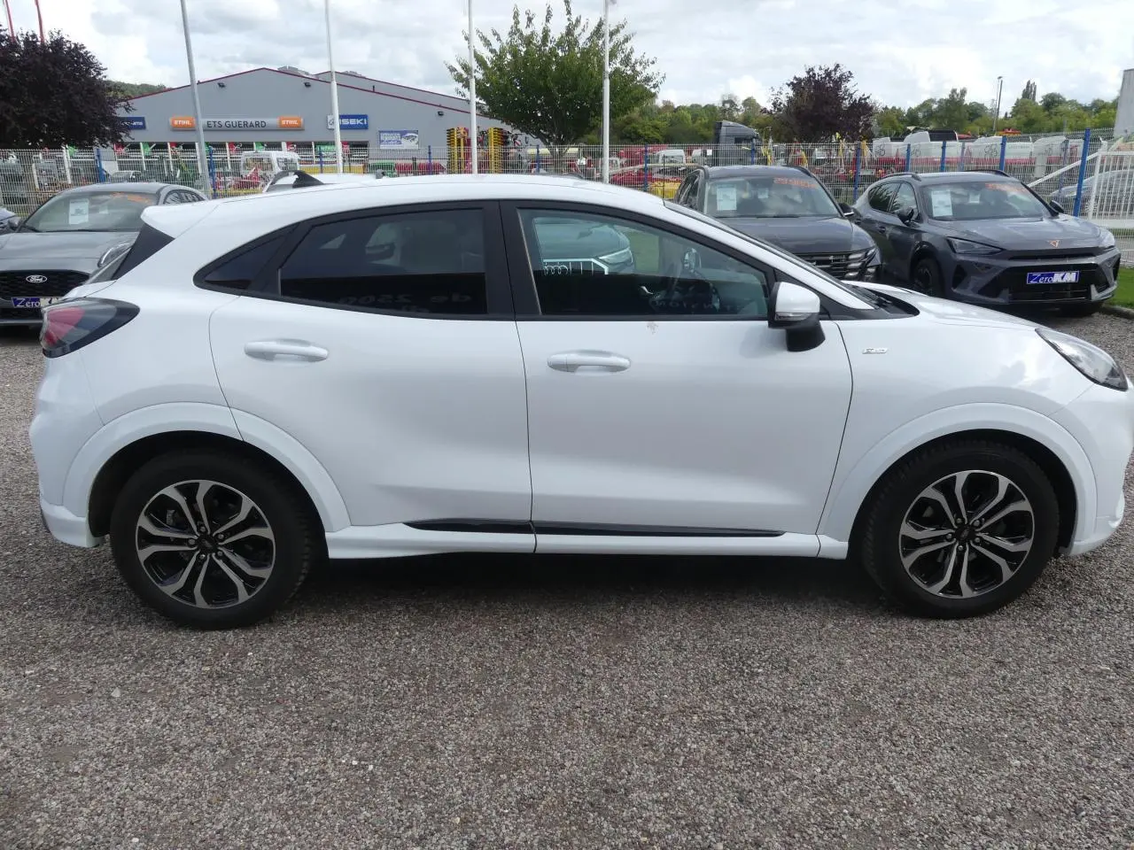 Ford Puma blanc en vue de profil côté gauche, avec vitres arrière surteintées et jantes alliage noires.