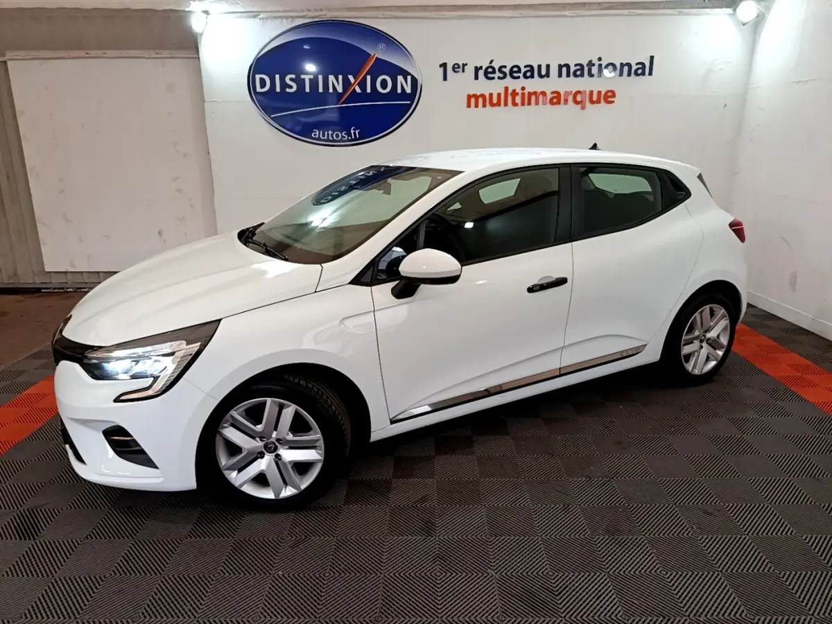 Renault Clio Business blanc vue de profil côté gauche avec feux LED allumés dans un showroom intérieur.