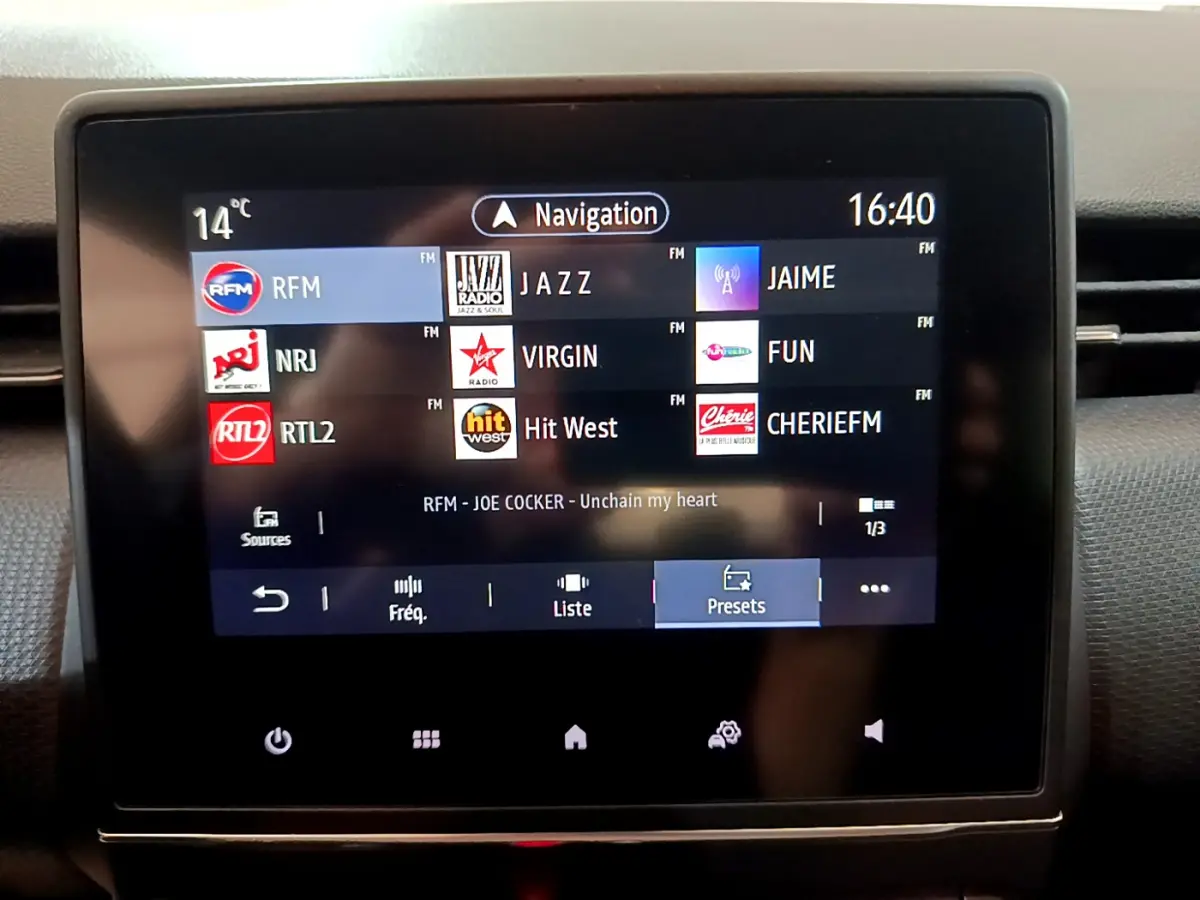 Écran tactile central de la Renault Clio Business blanc 2021 affichant les stations radio et la navigation.