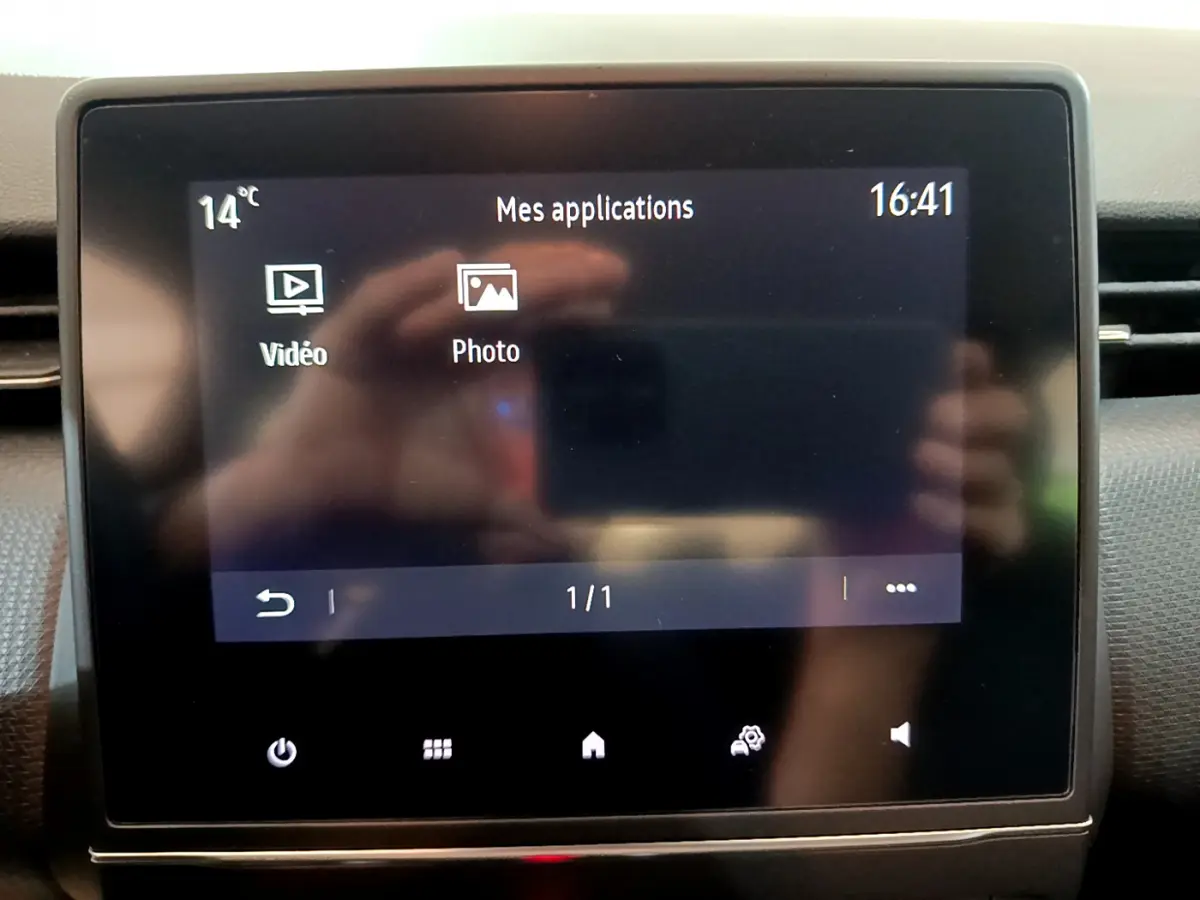 Écran tactile central de la Renault Clio Business blanc 2021 affichant les applications vidéo et photo, vue rapprochée.