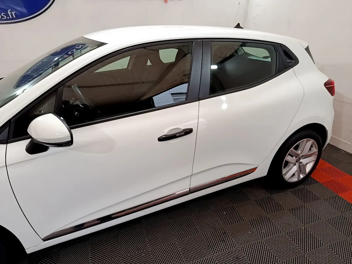 Profil côté gauche d'une Renault Clio Business blanche, mettant en valeur ses lignes épurées et les jantes alliage.