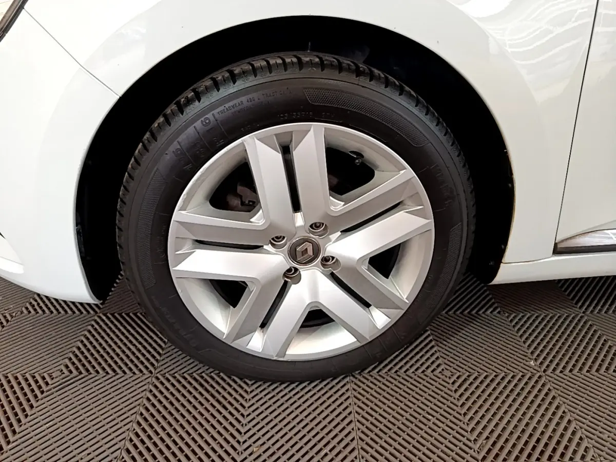 Gros plan sur la roue avant gauche blanche de la Renault Clio Business SCe 65 avec jante alliage argentée au design moderne.