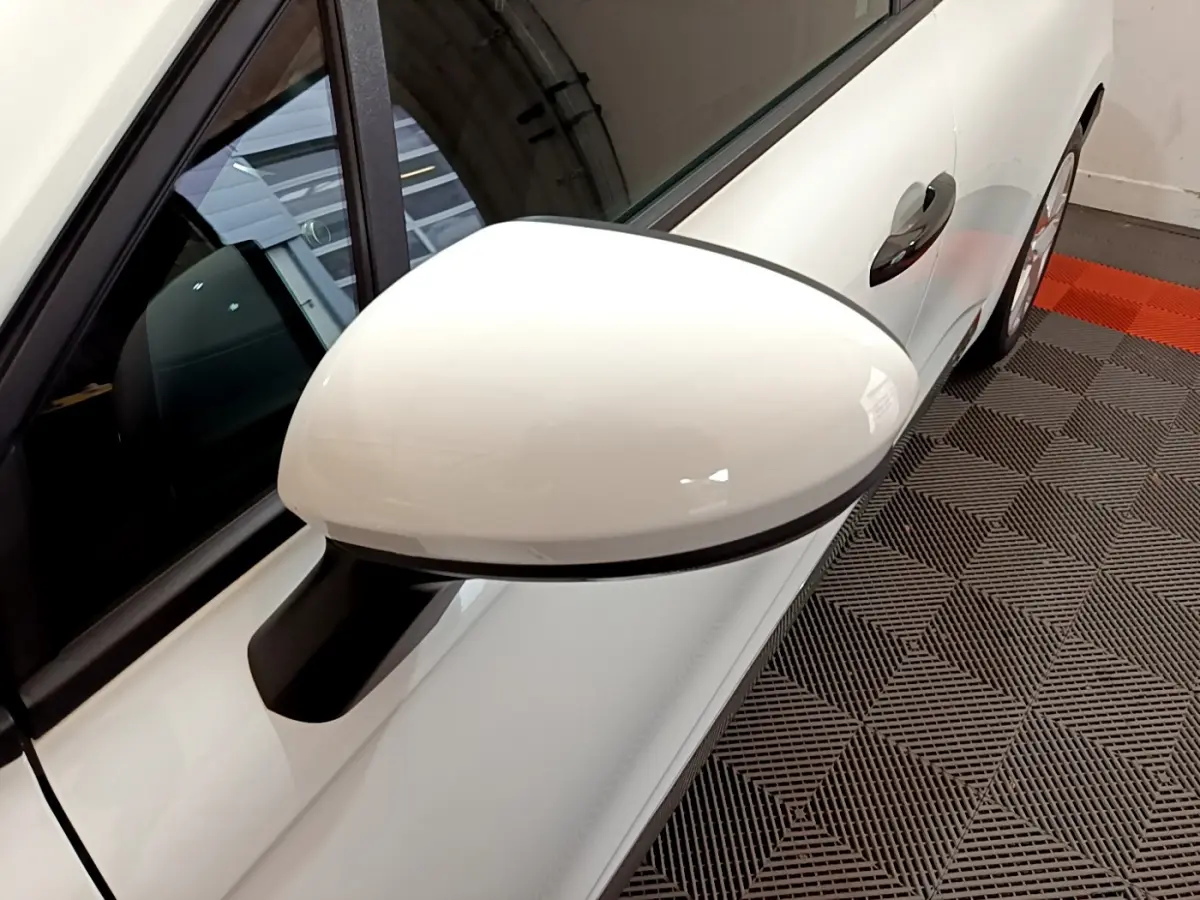 Rétroviseur droit blanc de la Renault Clio Business 2021, avec poignée de porte et partie latérale visibles.