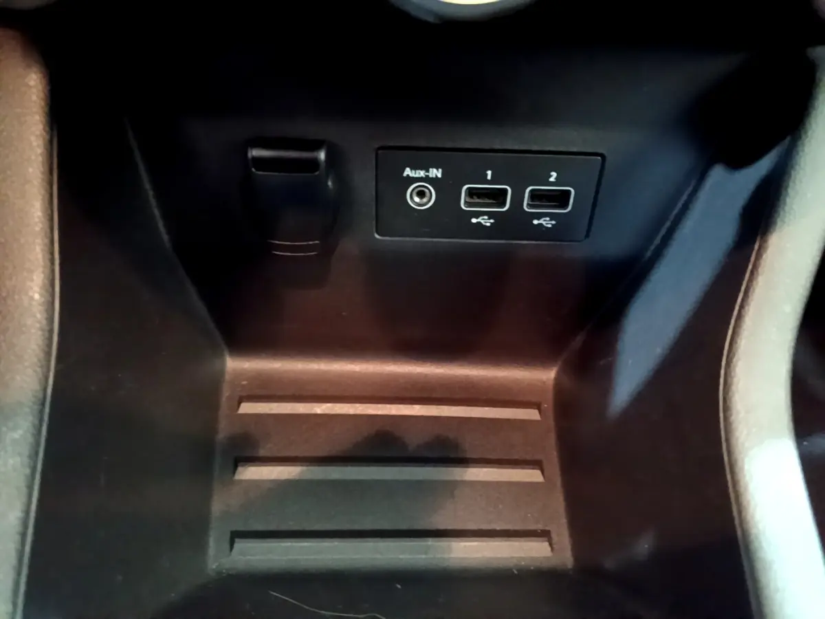 Prise USB et Aux-In dans le compartiment central d'une Renault Clio Business blanche, vue rapprochée intérieure.