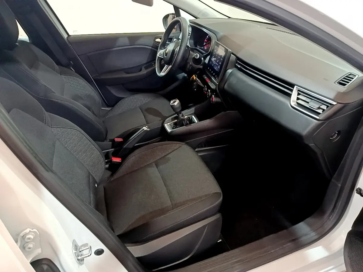 Intérieur avant droit d'une Renault Clio Business blanche 2021, sièges tissu noirs et tableau de bord avec écran tactile.