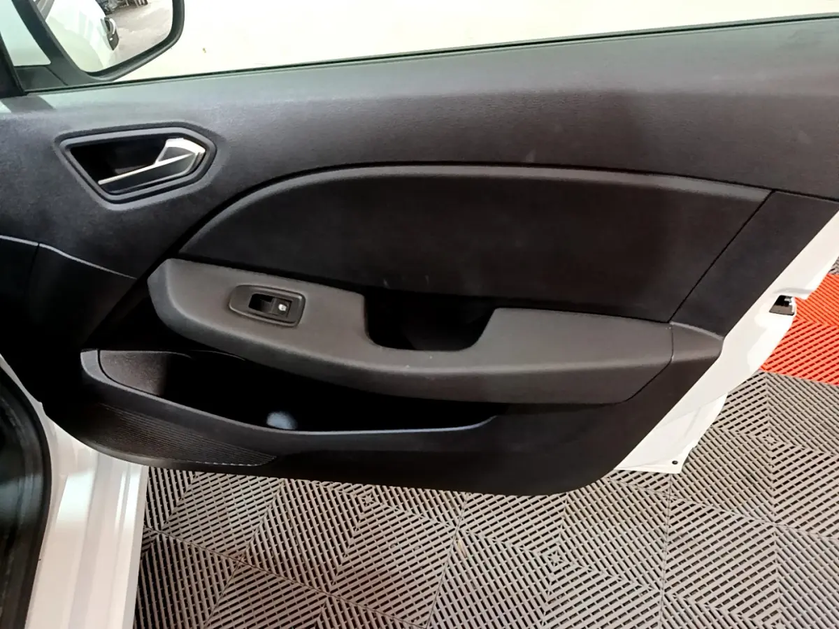 Vue rapprochée de la porte avant gauche blanche de la Renault Clio Business avec panneau intérieur noir et commande de vitre.