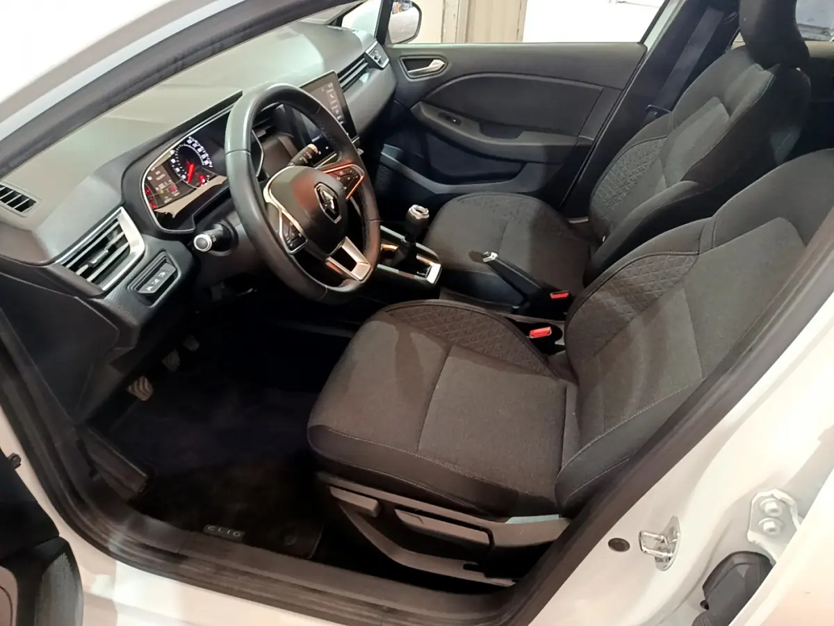 Intérieur avant droit de Renault Clio Business blanc 2021, sièges tissu gris et tableau de bord avec écran tactile.