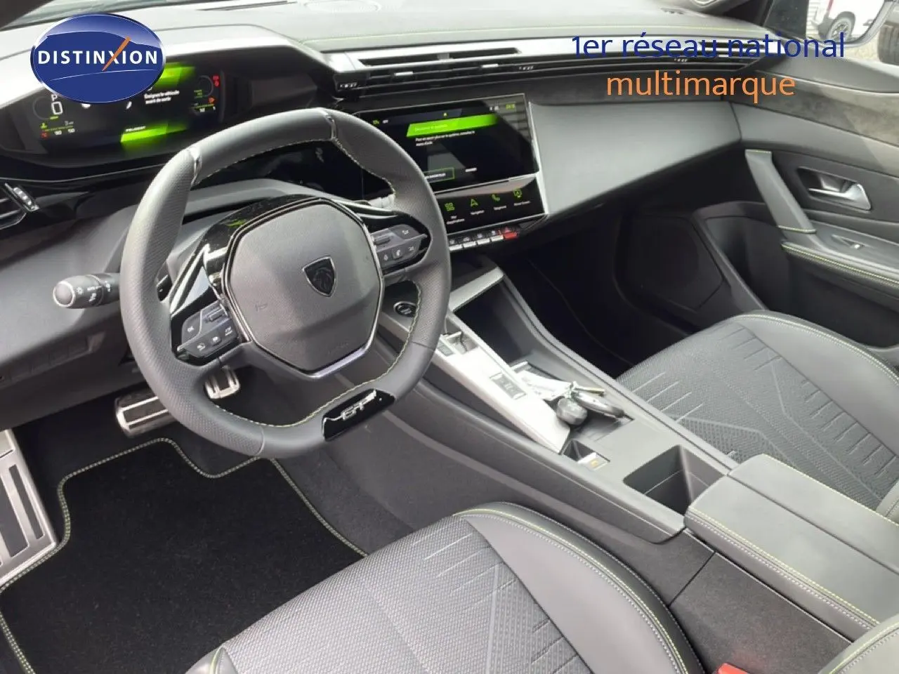 Vue intérieure côté conducteur de la Peugeot 308 1.2 Hybrid 145ch GT avec sellerie tissu noir et volant cuir multifonction.