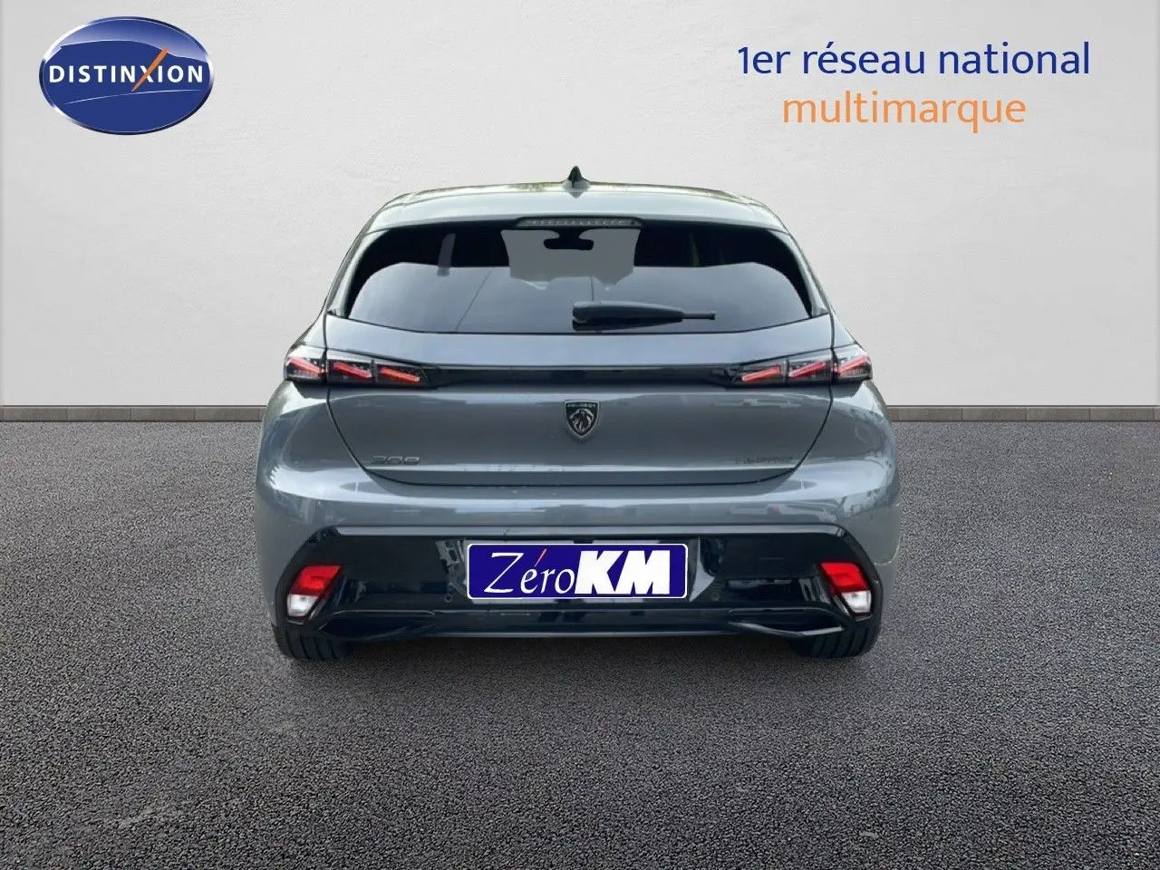 Vue arrière d'une Peugeot 308 gris selenium metal avec feux LED et vitrage teinté, stationnée sur sol gris.