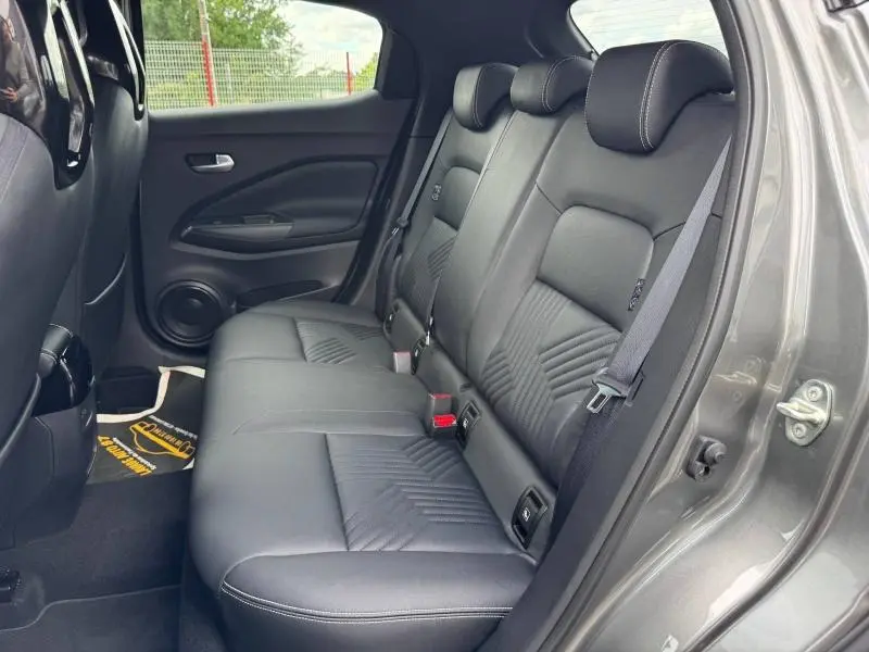 Vue intérieure côté droit des sièges arrière noirs en cuir du Nissan Juke 1.0 DIG-T Tekna 2025 avec ceinture de sécurité visible.