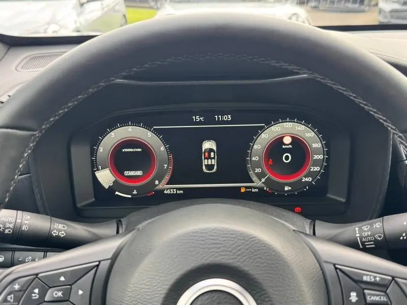 Vue depuis le siège conducteur du tableau de bord numérique du Nissan Juke 2025 noir, avec compte-tours et vitesse à zéro.