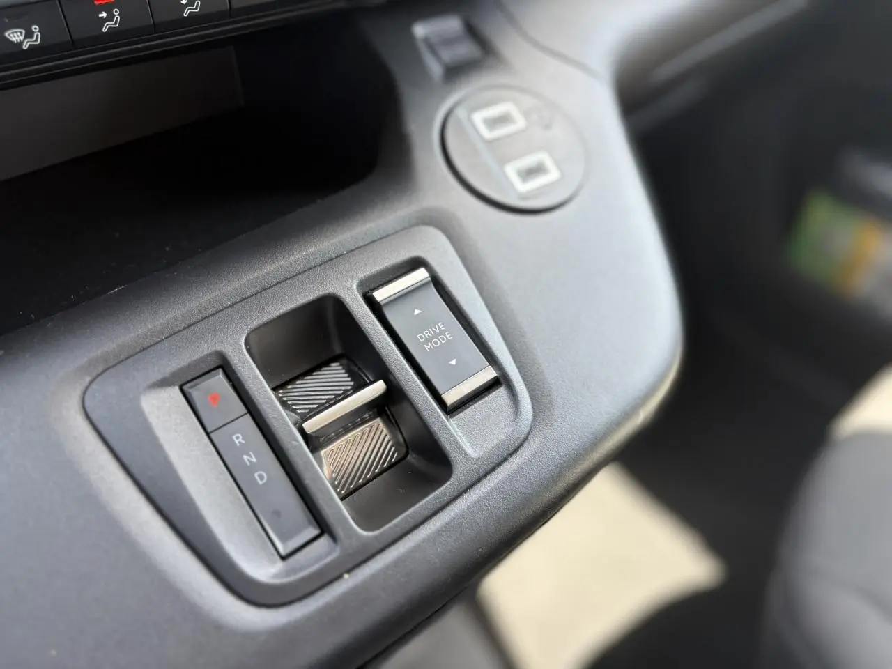 Gros plan sur la console centrale de la Citroën Berlingo ë-136, avec commandes de boîte automatique et mode de conduite.