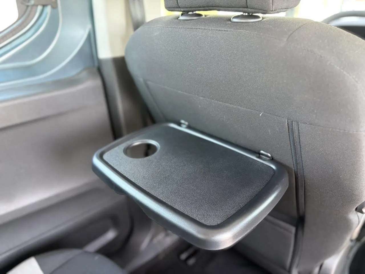 Tablette aviation noire rabattable sur le dossier du siège avant dans l'habitacle du Citroën Berlingo ë-136 bleu Kiama.