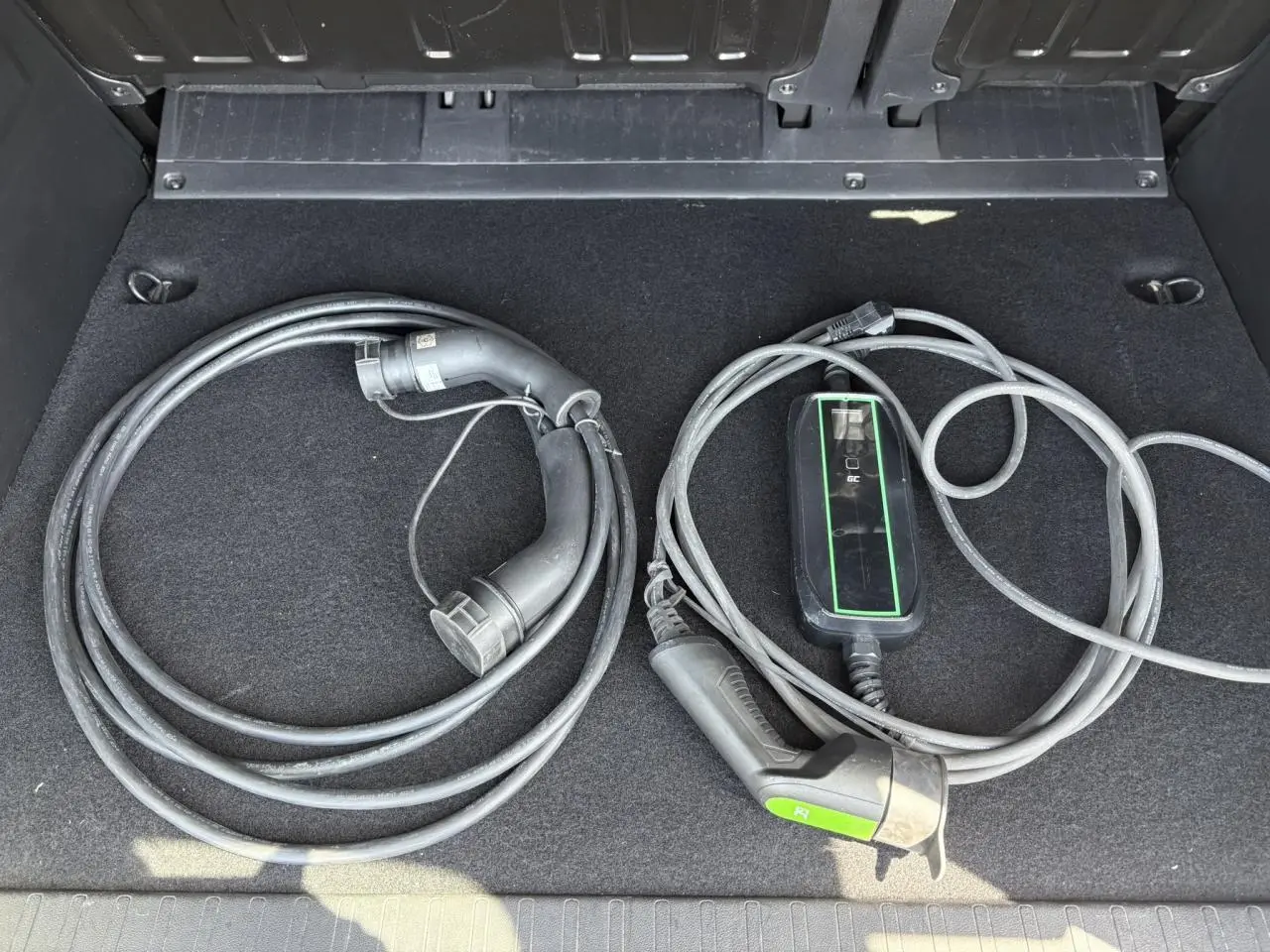 Câbles de recharge électrique rangés dans le coffre d’un Citroën Berlingo ë-136 54kWh bleu Kiama.