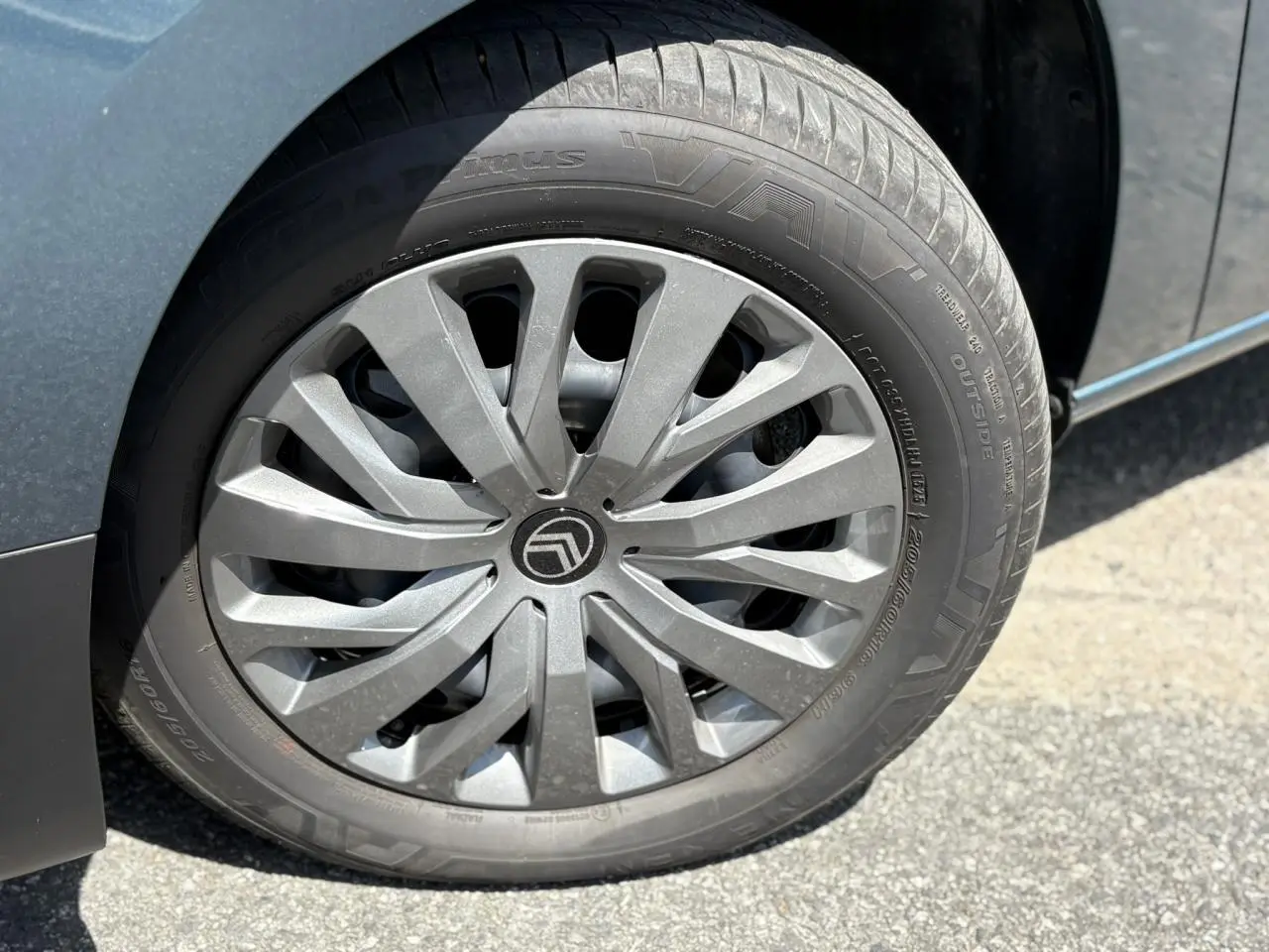 Gros plan sur la jante tôlée 16 pouces avec enjoliveur gris du côté gauche d’un Citroën Berlingo bleu Kiama.