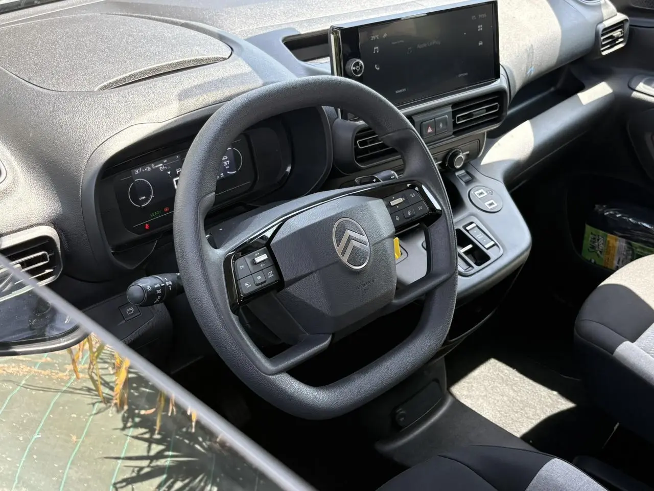 Vue intérieure du poste de conduite du Citroën Berlingo ë-136 2025, avec volant multifonction et écran tactile central.