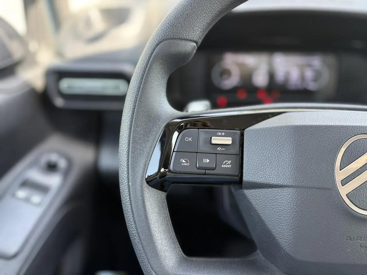 Gros plan sur le volant multifonction gris du Citroën Berlingo ë-136 2025 avec commandes intégrées côté gauche.