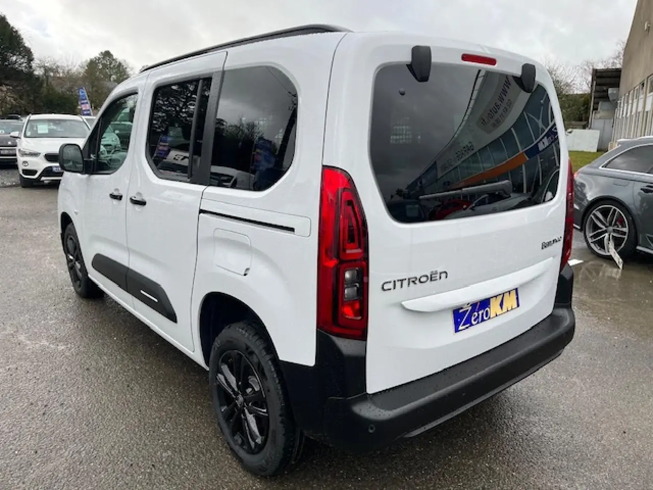 Vue 3/4 arrière droite d'un Citroën Berlingo Multispace blanc 2025 avec vitres teintées et jantes noires.