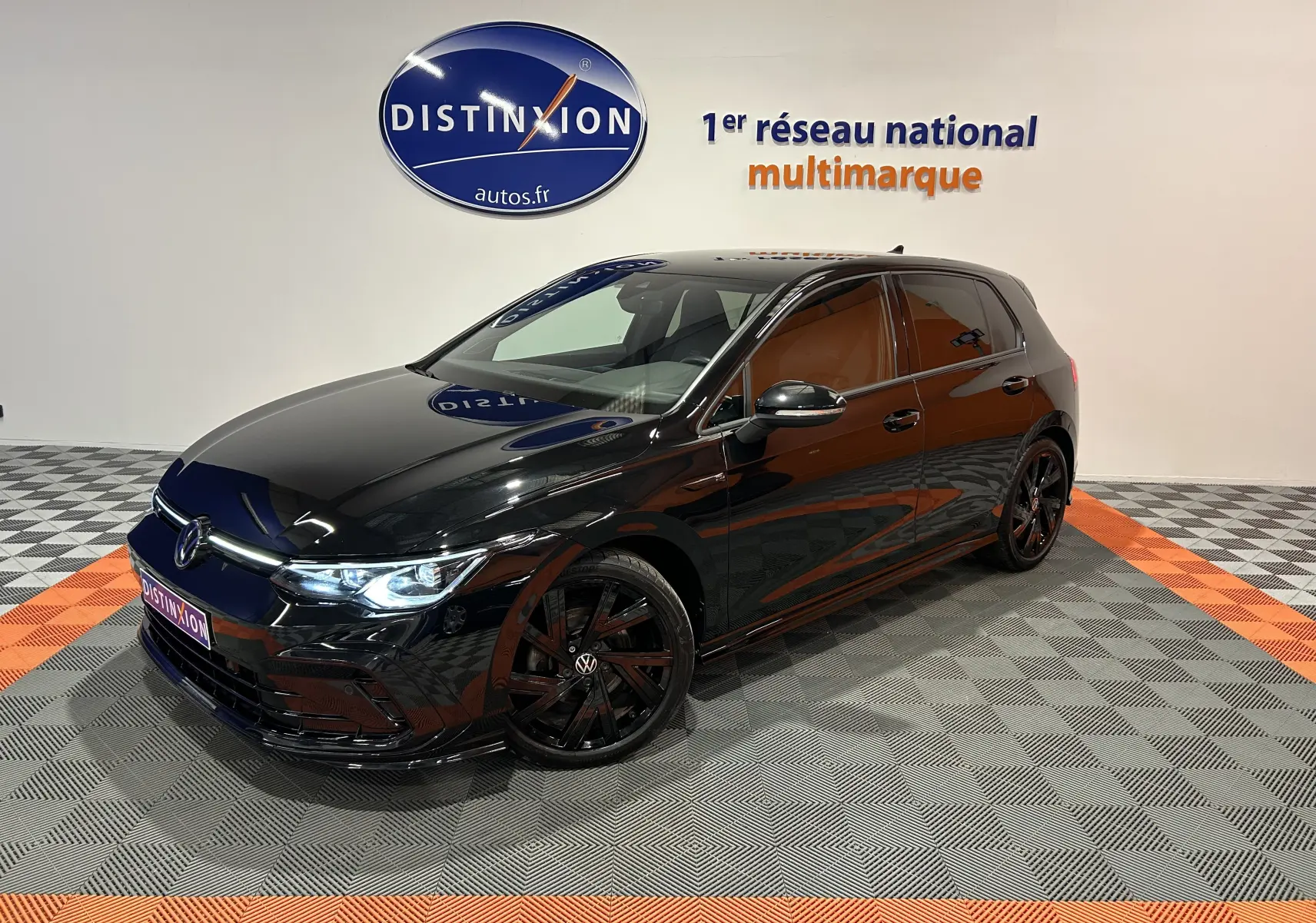Volkswagen Golf VIII eTSI noire métal en 3/4 avant droit, avec jantes noires et phares LED allumés.