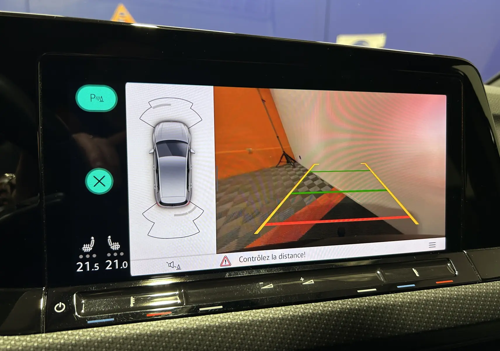 Écran intérieur de la Volkswagen Golf VIII eTSI montrant la caméra de recul avec guidage coloré et vue 360° du véhicule.