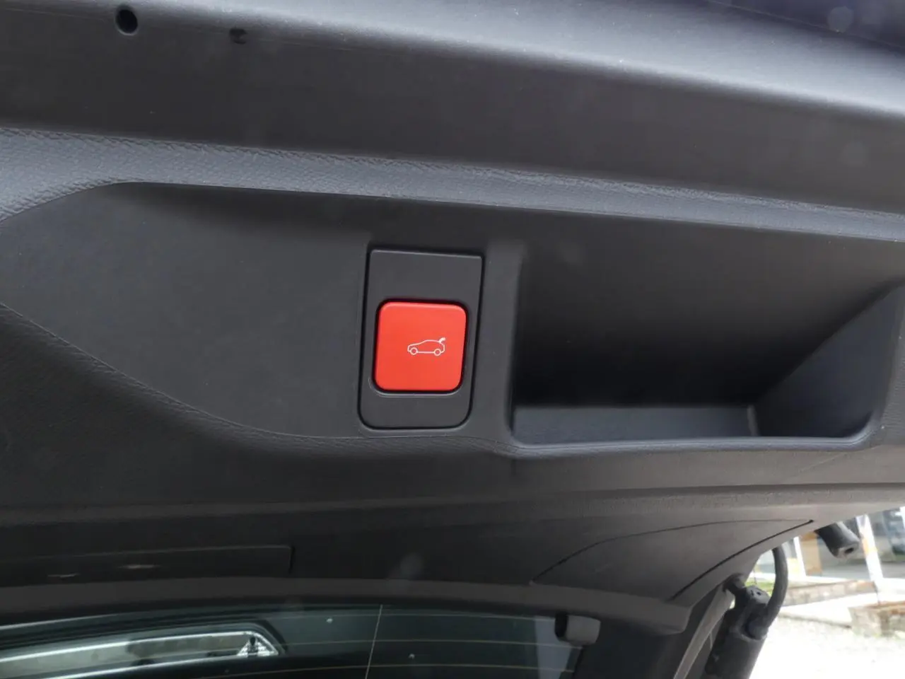 Bouton rouge d'ouverture motorisée du hayon sur le coffre d'une DS4 gris métallisé 2024 Cross Rivoli.