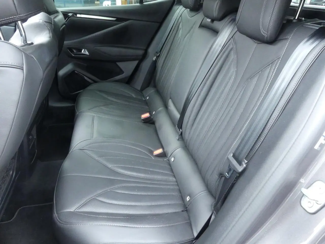 Vue côté droit des sièges arrière en cuir noir du DS4 Cross Rivoli 2024 avec détails de couture élégants.