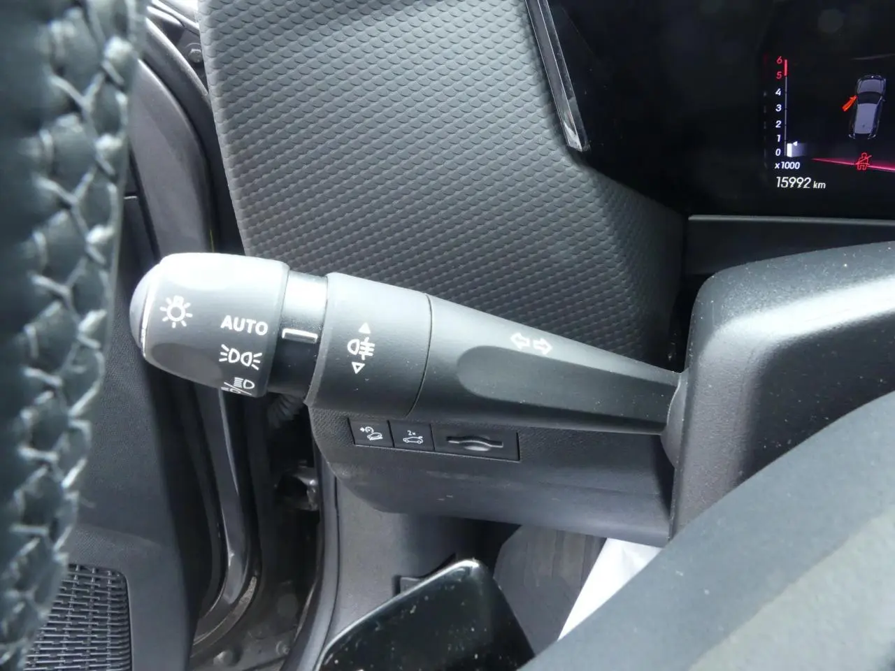 Gros plan sur la commande des feux et clignotants côté gauche du tableau de bord d'une DS4 gris métallisé 2024.