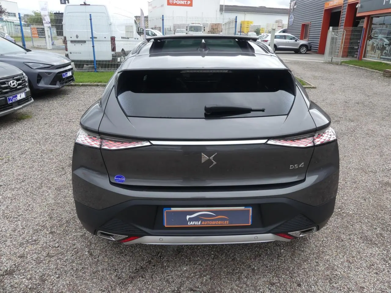 Vue arrière d'une DS4 gris métallisé avec feux arrière à effet 3D et double sortie d'échappement chromée.