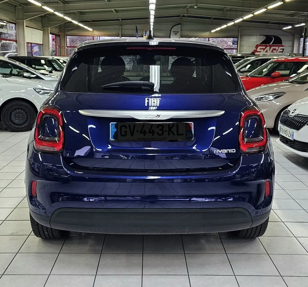 Vue arrière d'un FIAT 500X bleu hybride 2024, avec feux arrière distinctifs et logo FIAT centré sur le hayon.