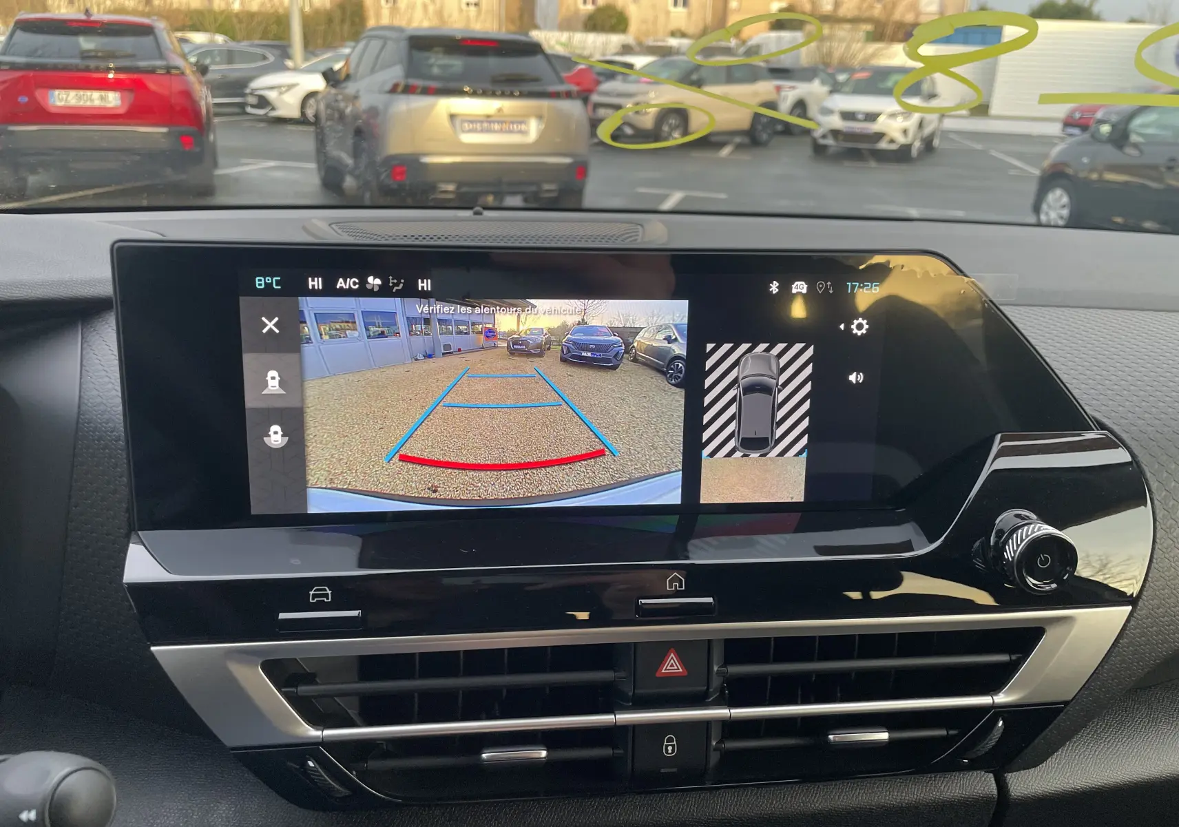 Vue intérieure du tableau de bord de la Citroën C4 hybride 2025, écran affichant la caméra de recul en marche.