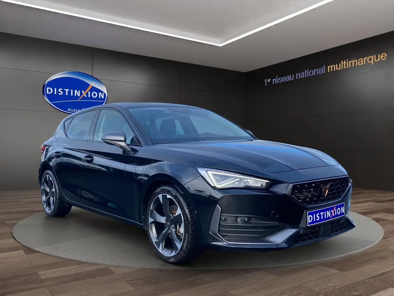 Vue 3/4 avant d'une CUPRA Leon noire 2023 avec jantes alliage bicolores et toit ouvrant panoramique.