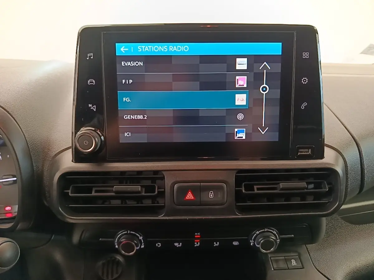 Écran tactile central affichant les stations radio dans l'habitacle du Citroën Berlingo blanc, vue de face.