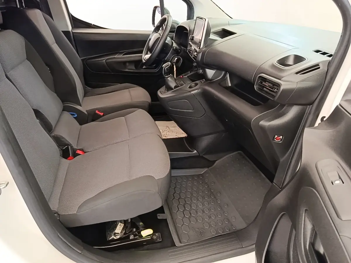 Vue intérieure côté conducteur du Citroën Berlingo blanc 2021, montrant sièges gris et tableau de bord avec écran tactile.