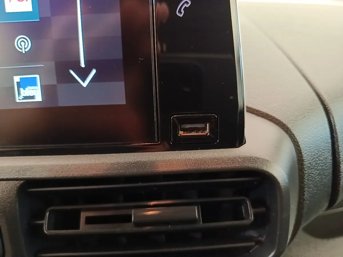 Gros plan sur la console centrale du Citroën Berlingo blanc, montrant un port USB à côté de l'écran tactile.