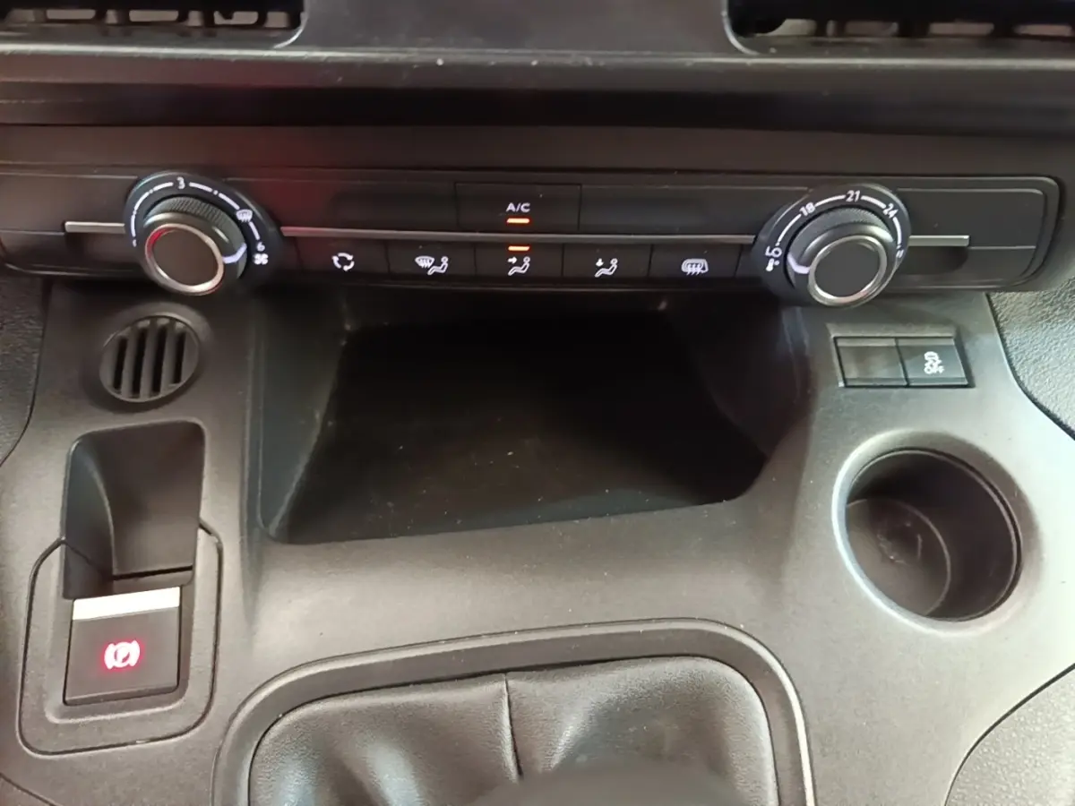 Vue rapprochée de la console centrale noire du Citroën Berlingo 2021 avec commandes climatisation et frein à main électrique.