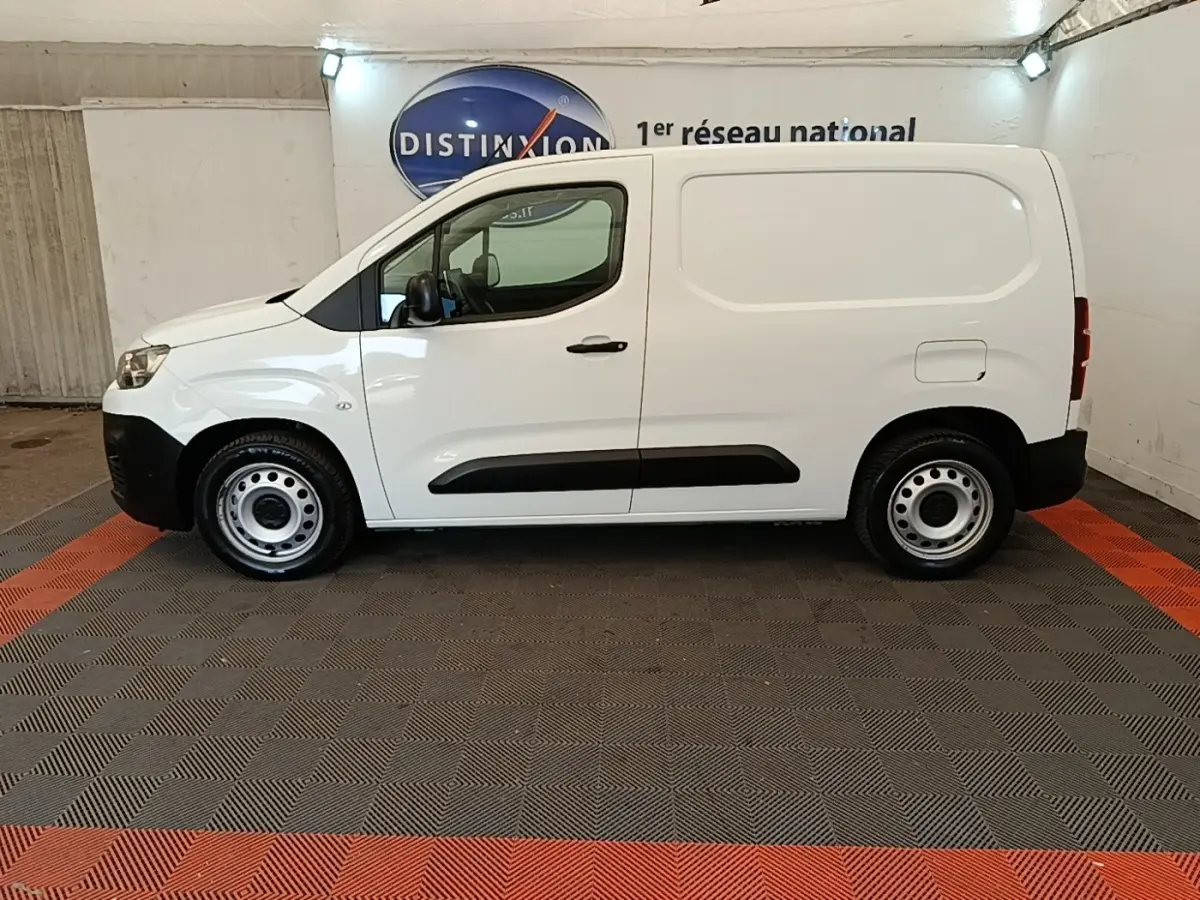 Vue de profil côté gauche d’un utilitaire Citroën Berlingo blanc avec jantes acier et protections latérales noires.