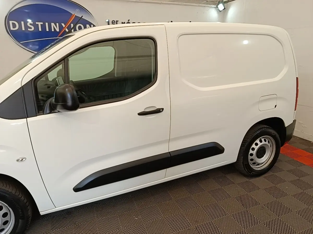 Vue latérale côté droit d’un utilitaire Citroën Berlingo blanc avec protections noires et jantes acier.