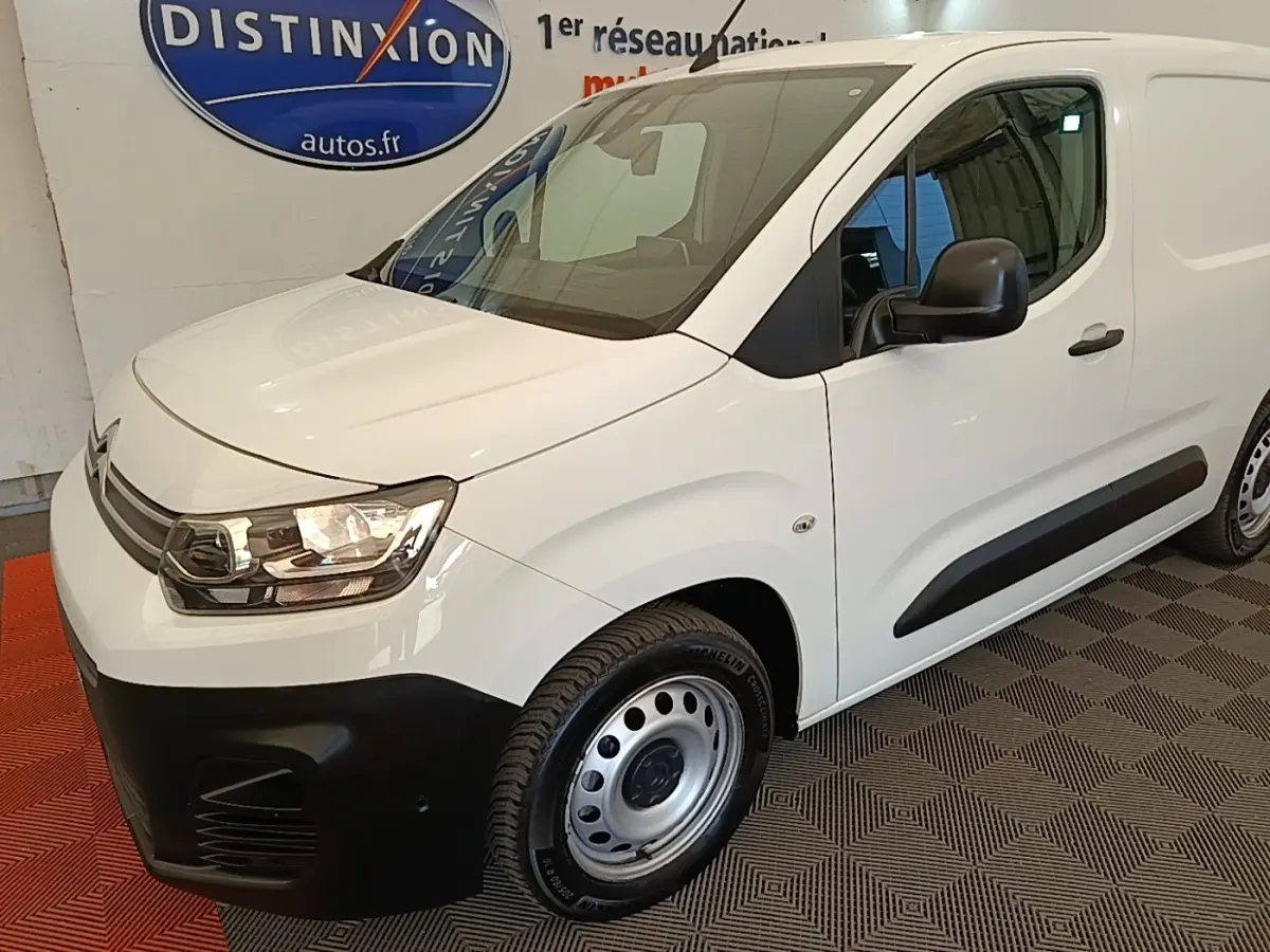 Vue 3/4 avant droit d’un utilitaire Citroën Berlingo blanc avec pare-chocs noir et jantes acier simples.