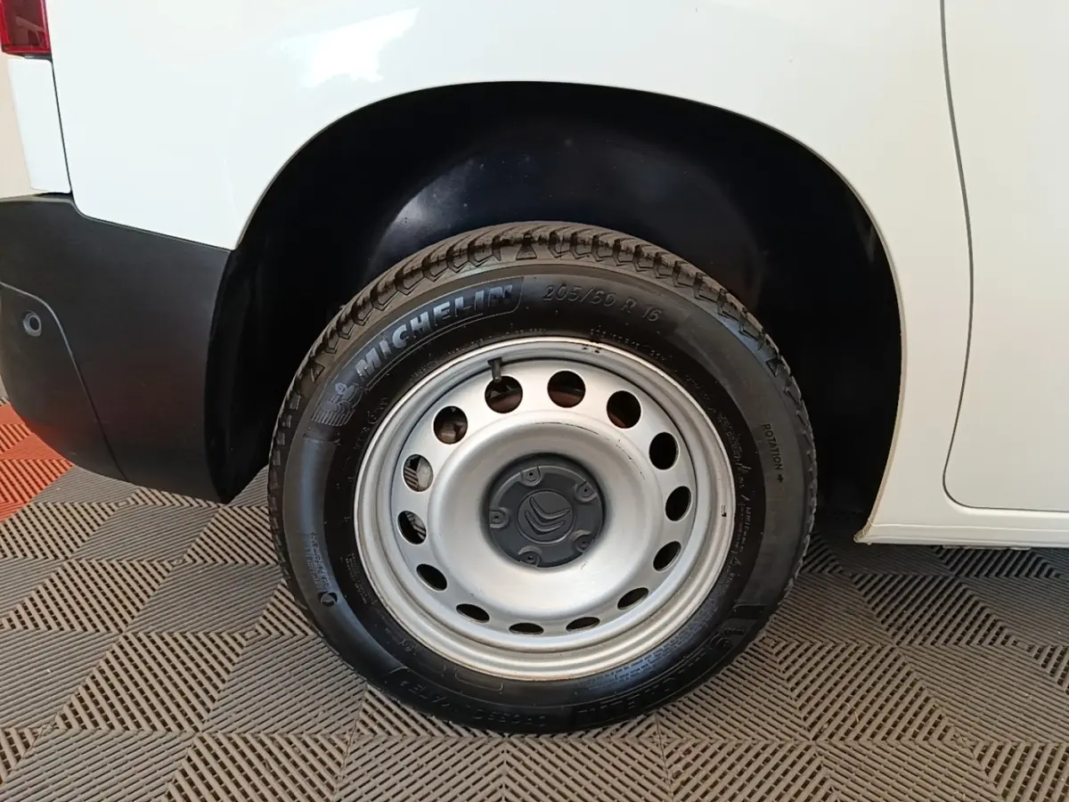 Gros plan sur la roue arrière droite d’un Citroën Berlingo blanc avec jante acier et pneu Michelin.
