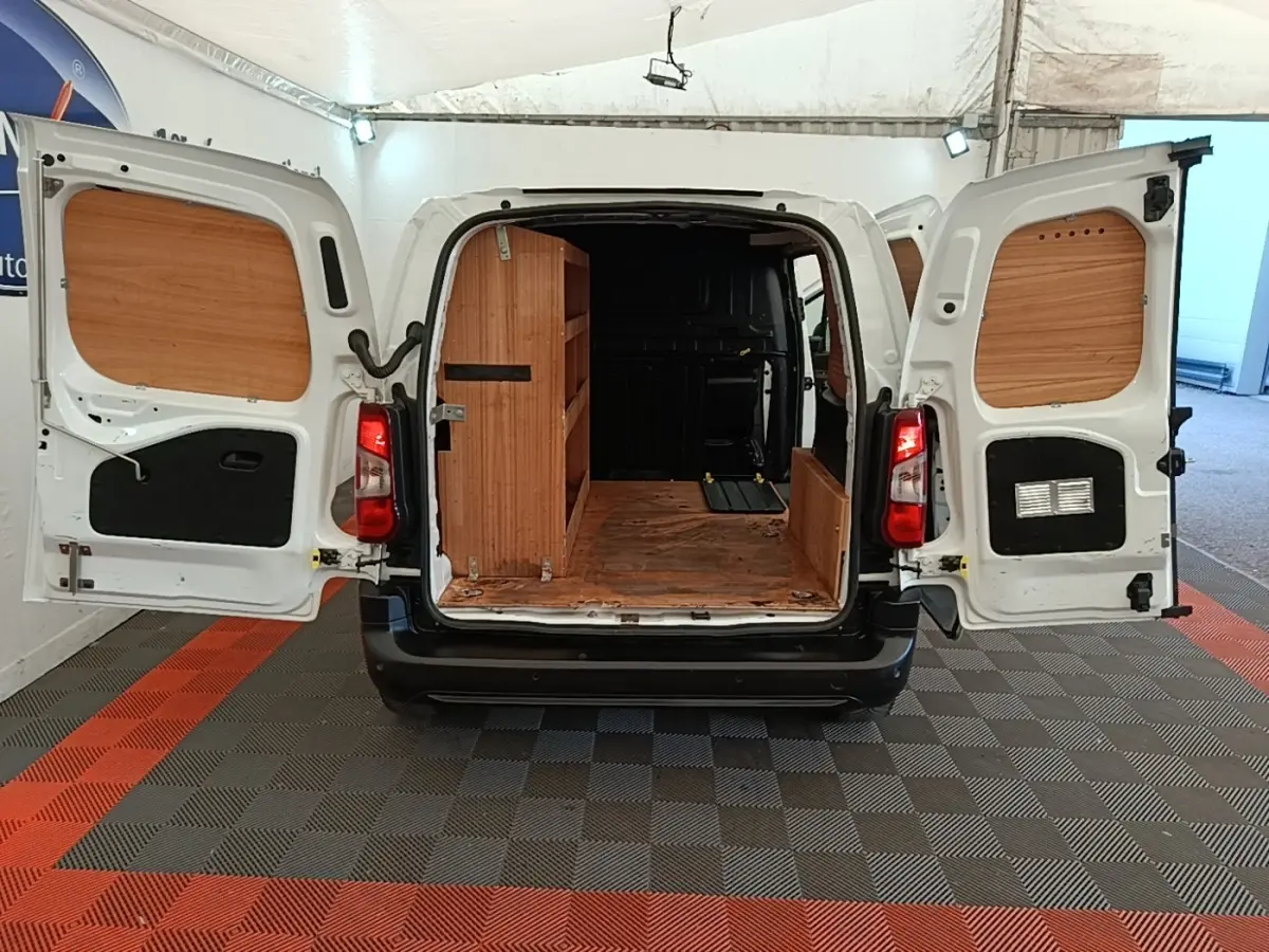 Vue arrière d’un utilitaire Citroën Berlingo blanc 2021 avec portes ouvertes et aménagements bois dans le coffre.