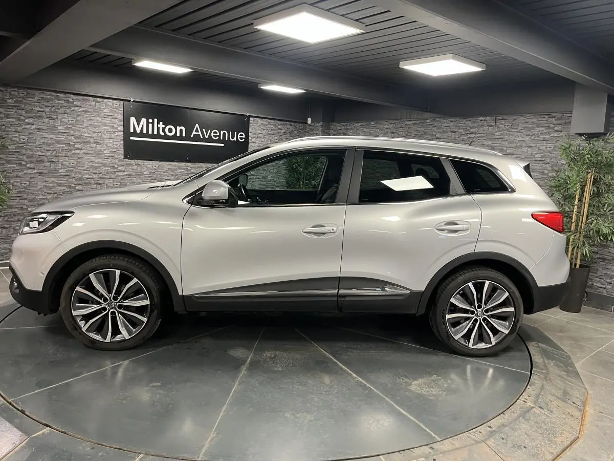 Renault Kadjar gris platine vu de profil côté gauche, avec jantes alliage 19 pouces et attelage fixe visible.