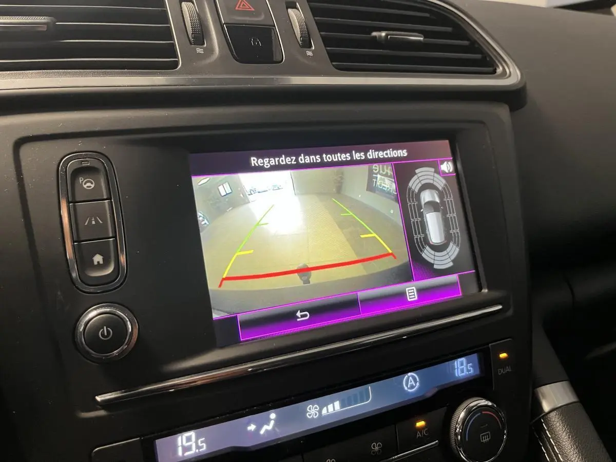 Écran central du Renault Kadjar gris montrant la caméra de recul et les capteurs de stationnement en intérieur.