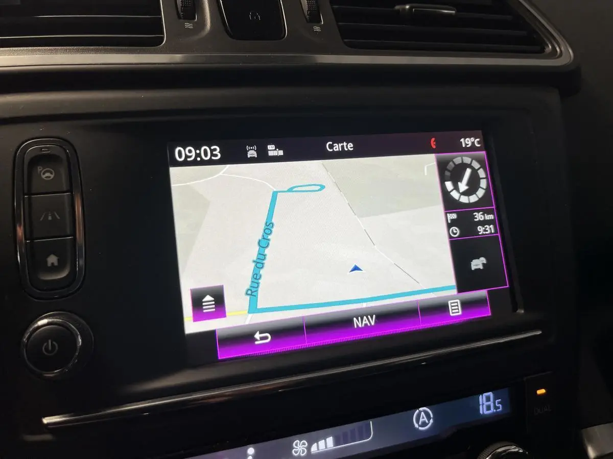 Écran tactile central du Renault Kadjar 2017 montrant la navigation avec carte et commandes autour en intérieur noir.