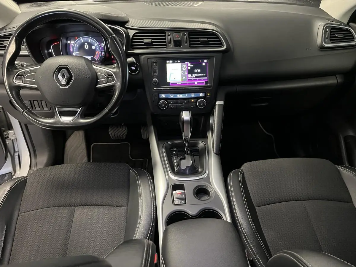 Vue intérieure avant du Renault Kadjar 2017 avec tableau de bord noir et console centrale intégrant levier de boîte auto.
