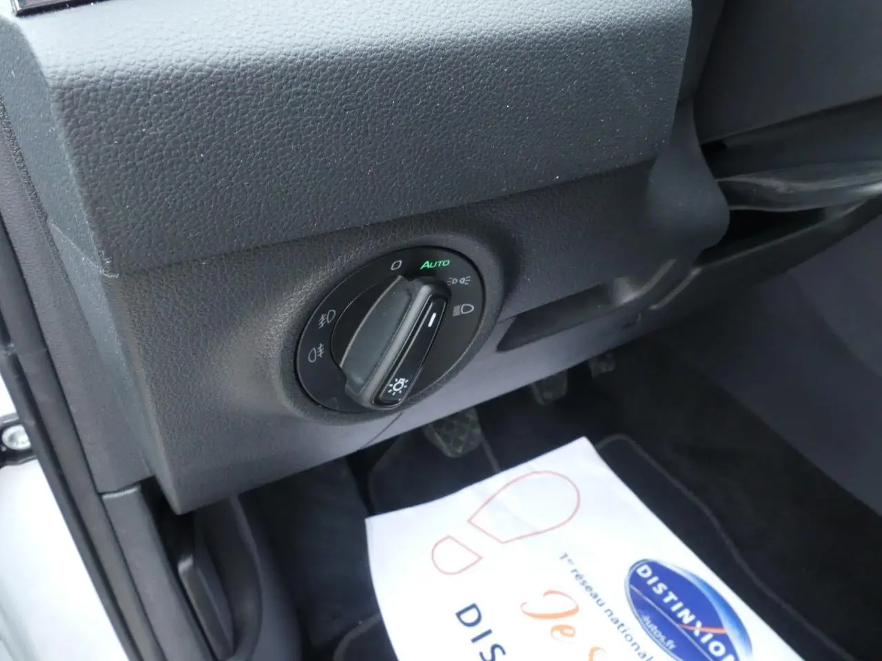 Gros plan sur le bouton de commande des phares côté gauche du tableau de bord du Skoda Karoq blanc 2024.